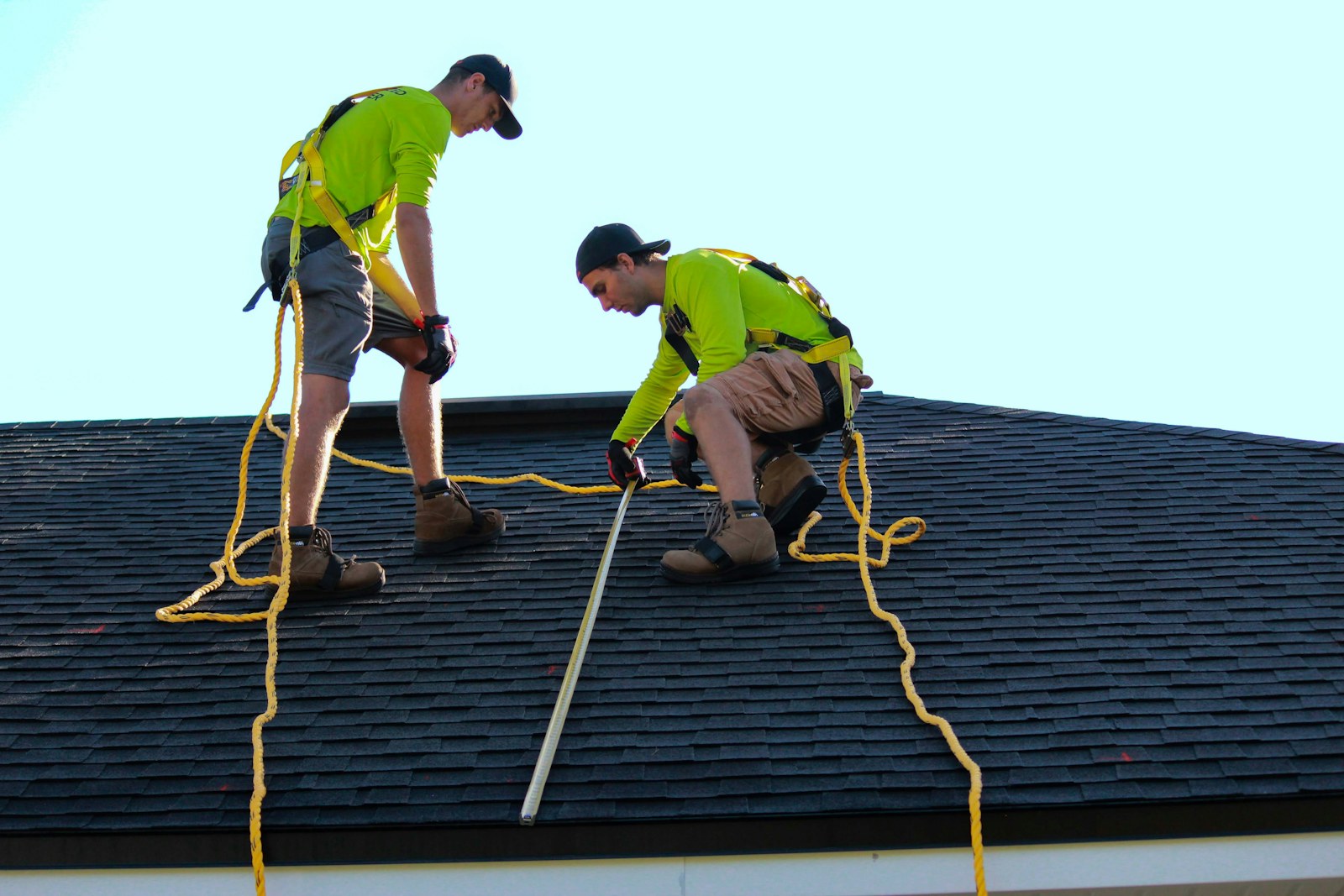 Roofer working a dark roof under a heavy sky