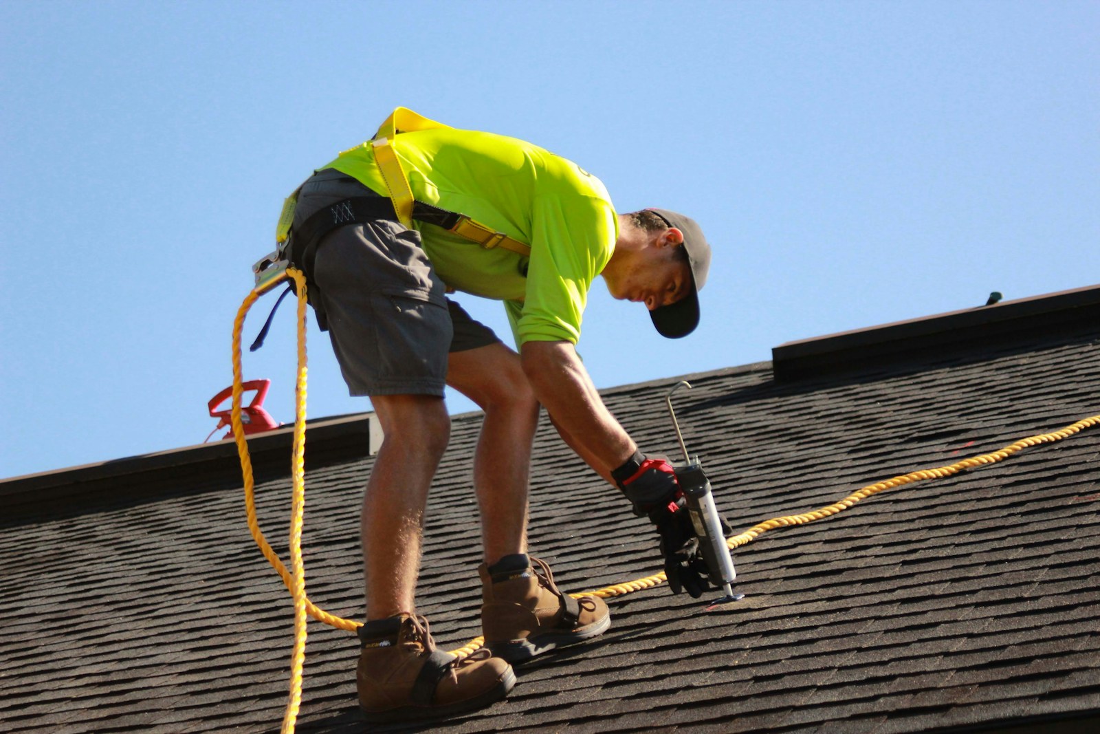 Roofer nailing down replacement shingles